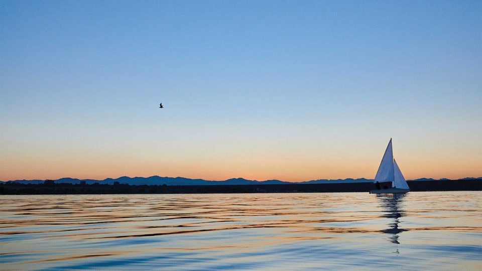 Sailboat on calm water to represent continued movement during a slow economy